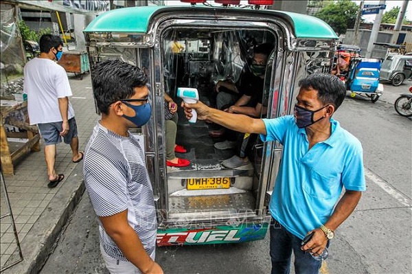 a jeepney driver checking body temperature for a passenger